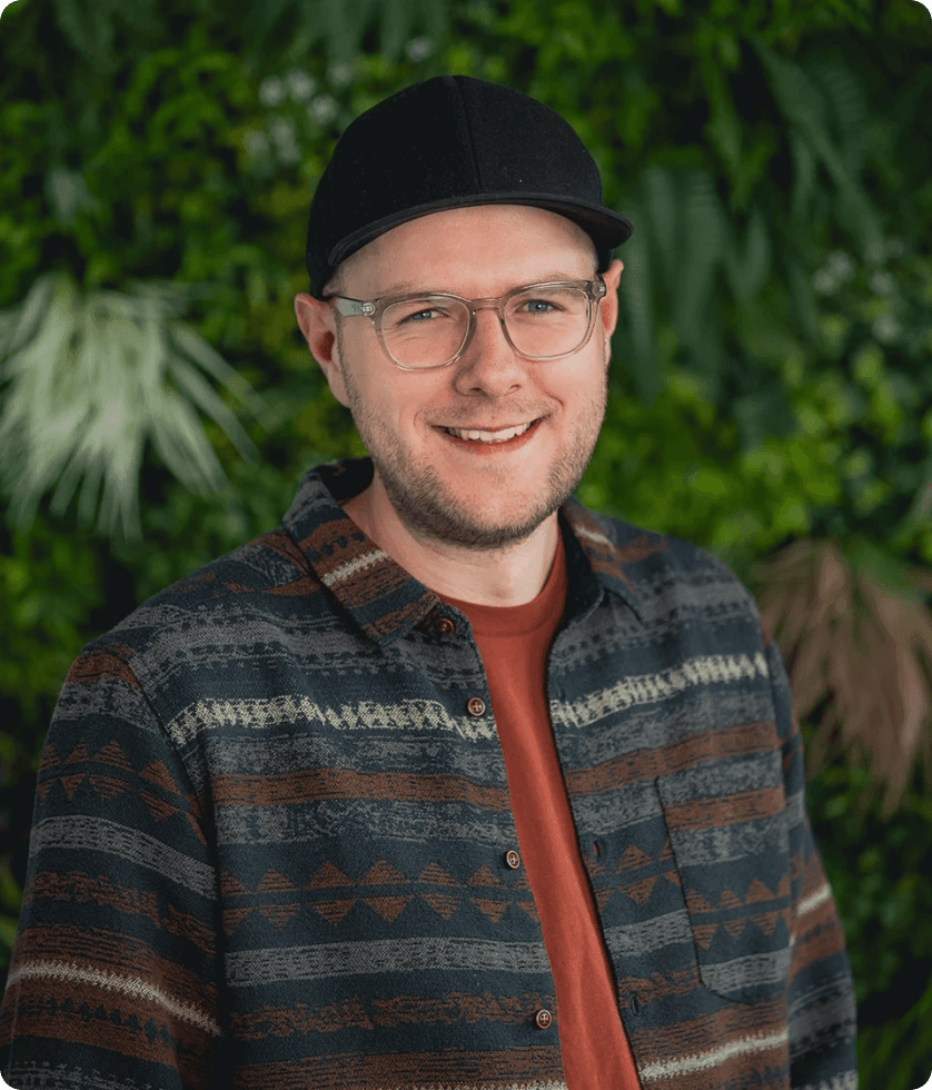 Business-Porträt von Matthias Rippel, Gründer von morgenrot, mit Brille und Cap vor grüner Pflanzenwand – authentisches Founder-Foto